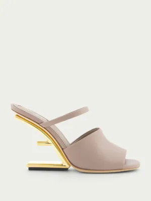 First high-heeled leather sandals