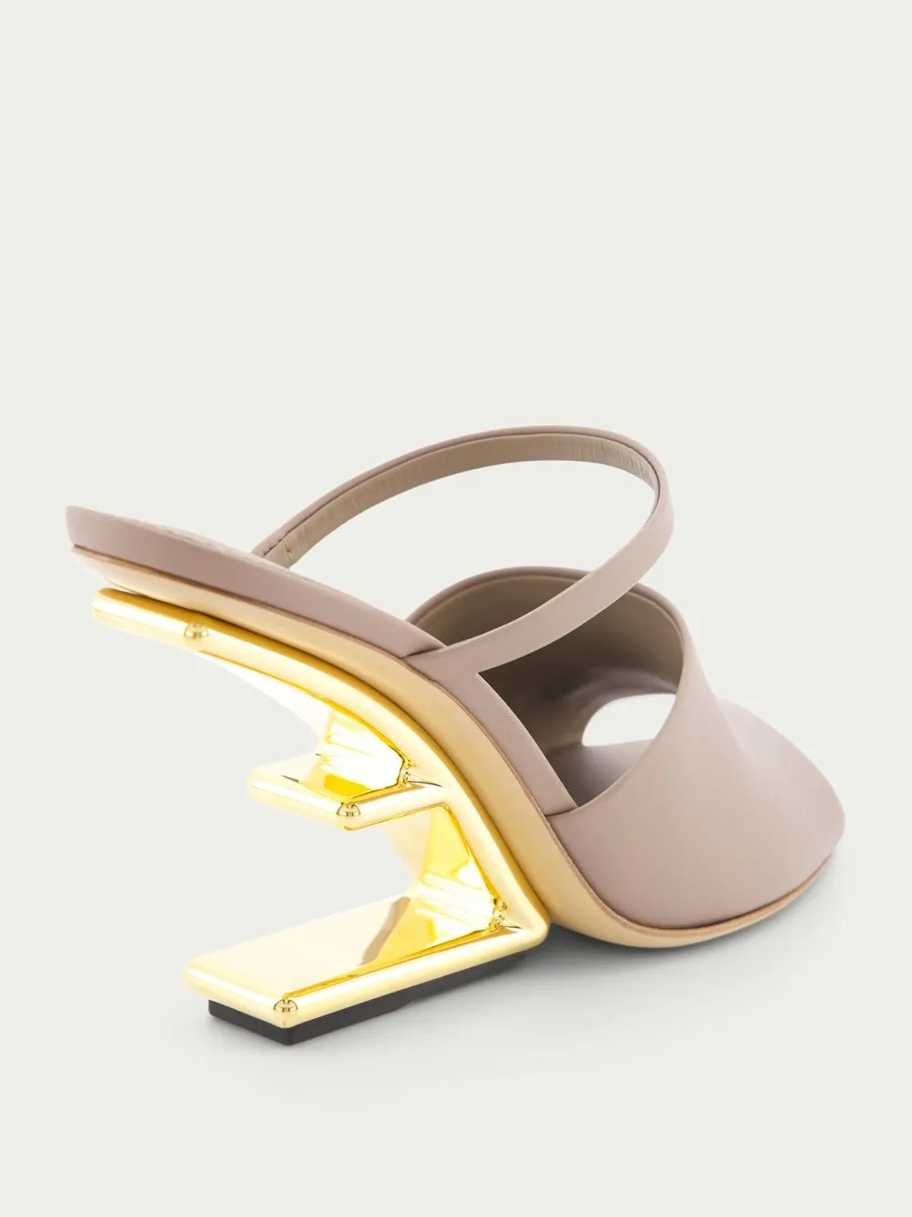 First high-heeled leather sandals
